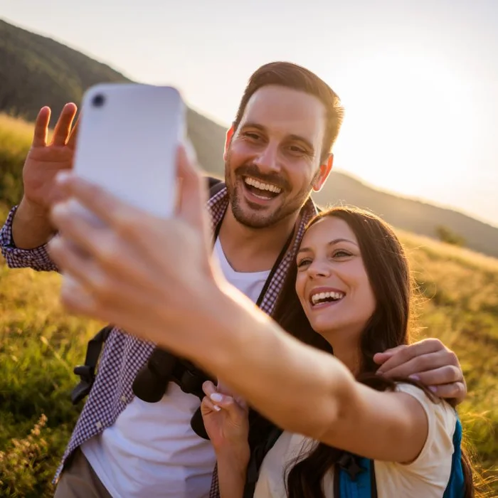Lachendes Paar macht ein Selfie in der Natur